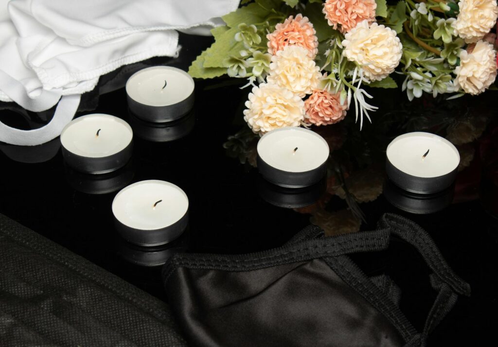 a close up shot of candles beside flowers