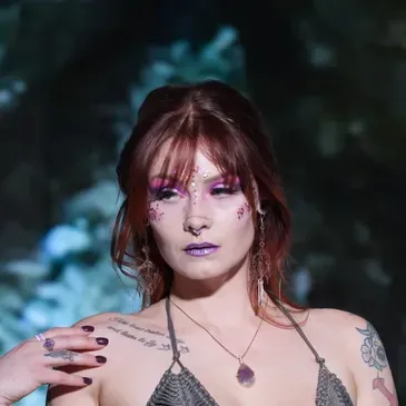 Avant-garde editorial makeup look with bold colors and creative embellishments on a LGBTQ model by Jessa Jaguar in St. Petersburg